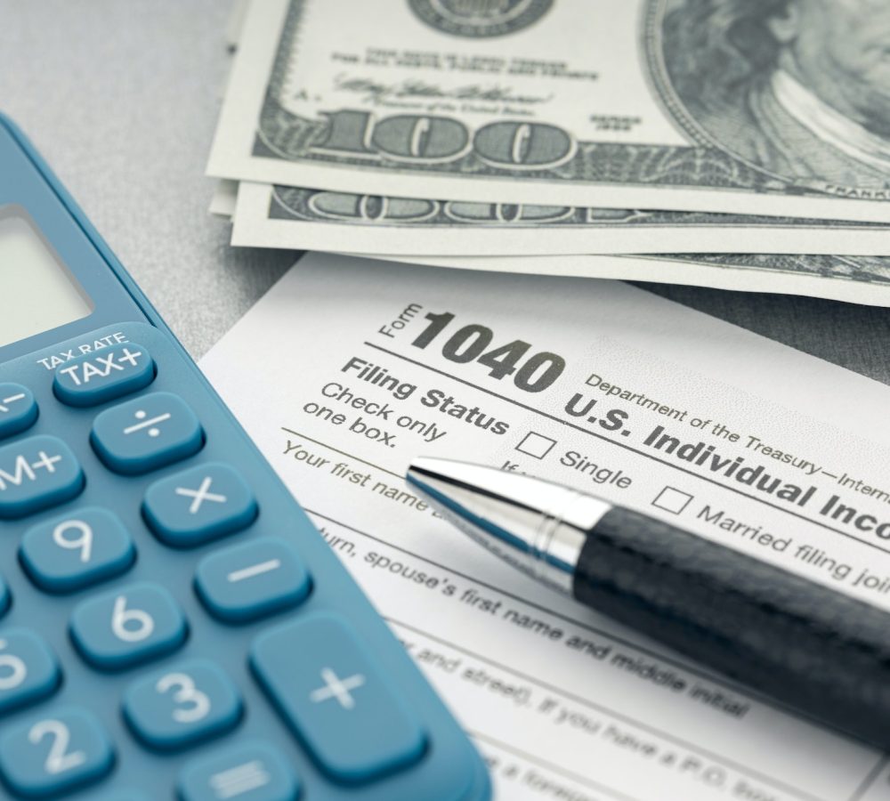 tax-form-calculator-money-and-pen-on-table.jpg